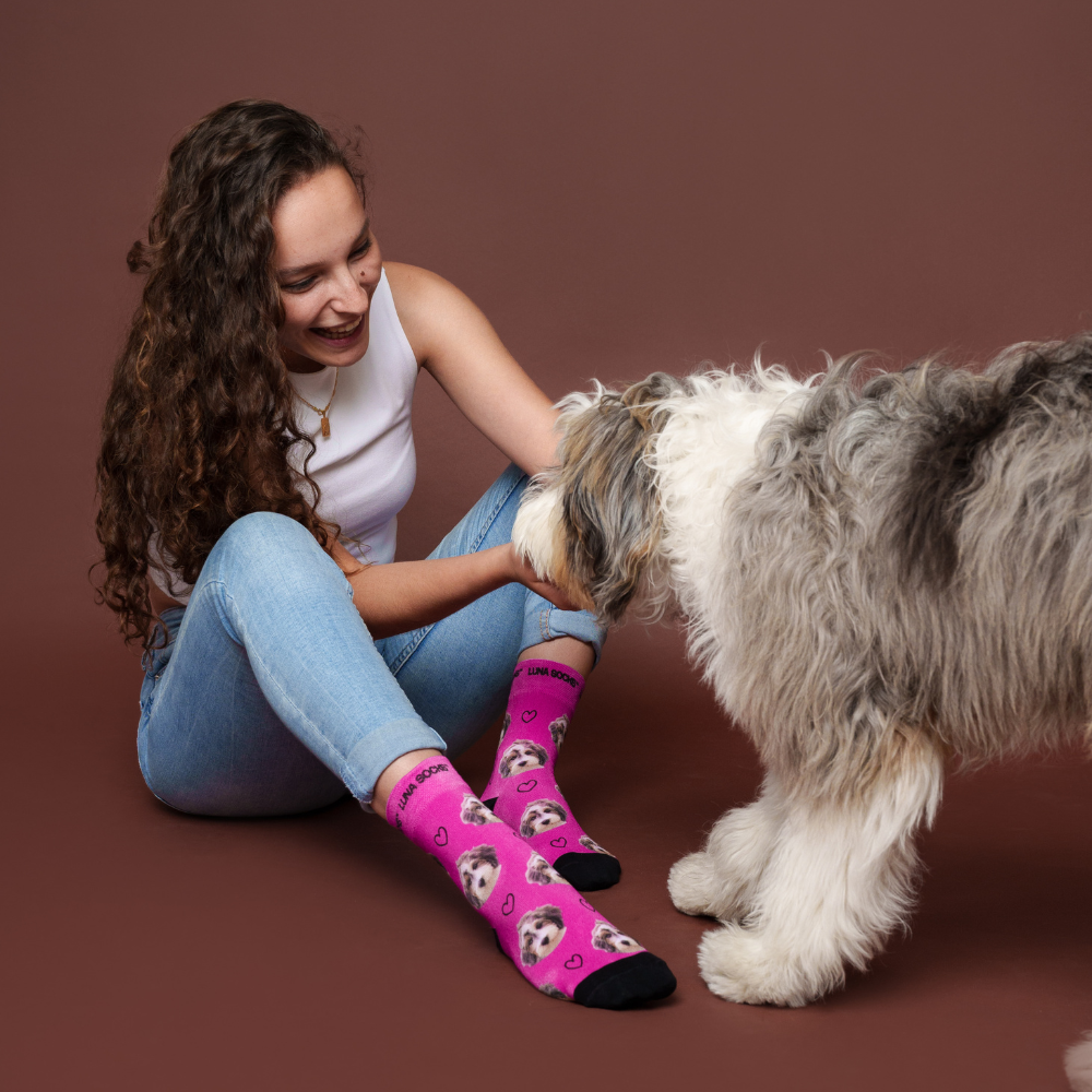 Girl with custom pet socks cuddling with dog